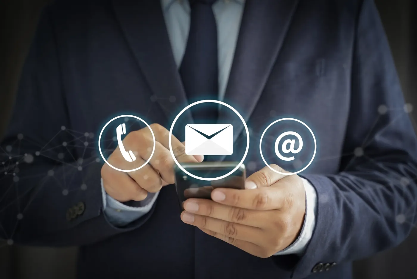 A person holding a phone beside illustrated telephone, envelope and email contact icons