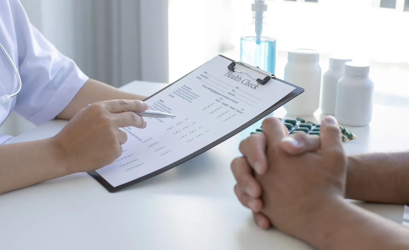 A healthcare professional reviewing information on a clipboard with a client