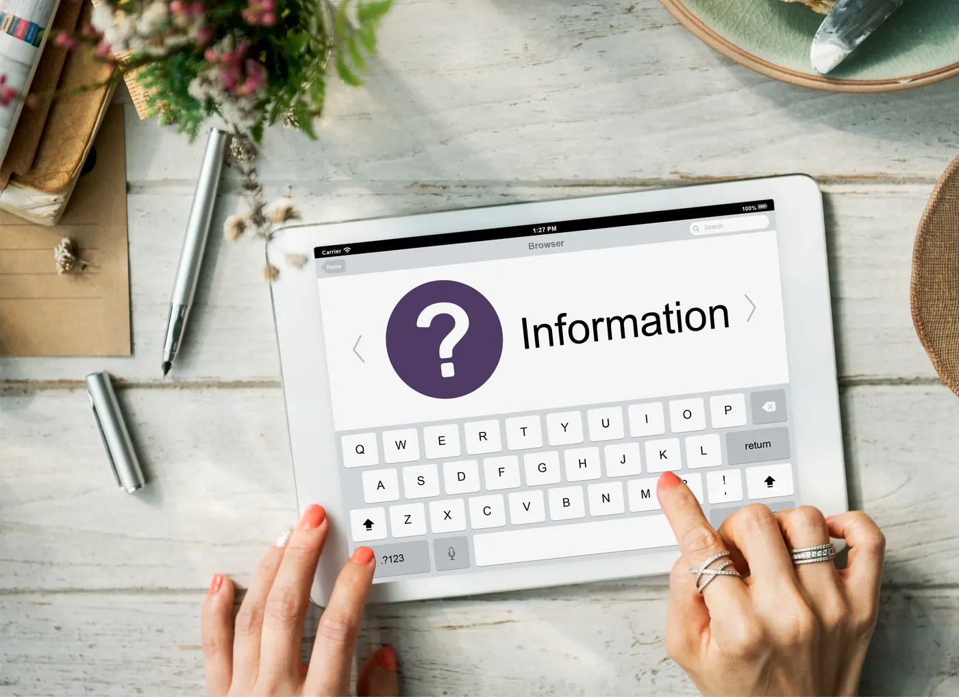 A person using a tablet to look up information, with a question mark shown on screen